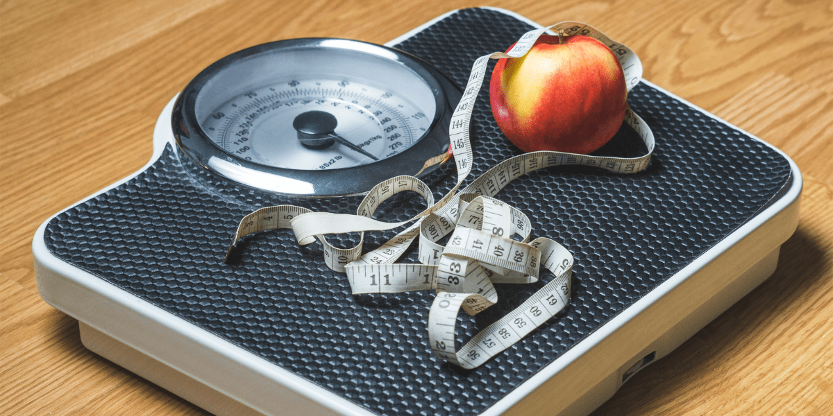 A scale, an apple and a tape measure.